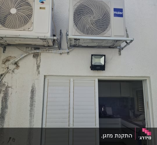 שני מזגנים מותקנים על קיר חיצוני ליד דלת